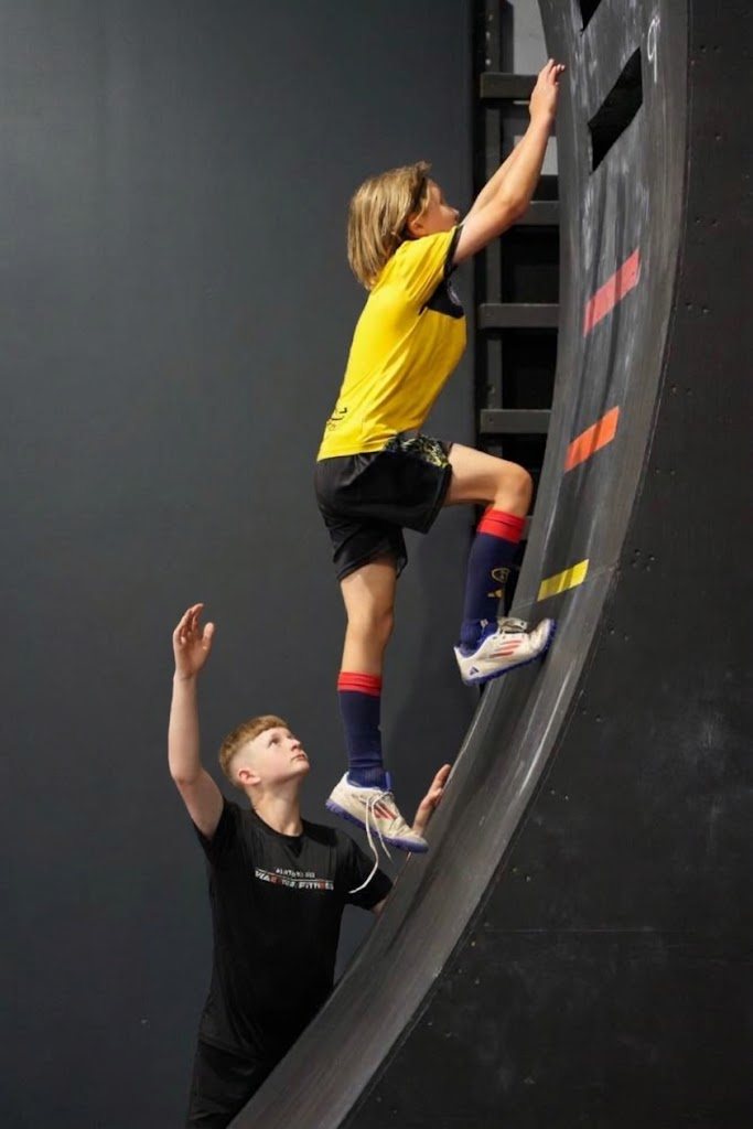 Kids climbing the ninja wall at an AWF birthday party