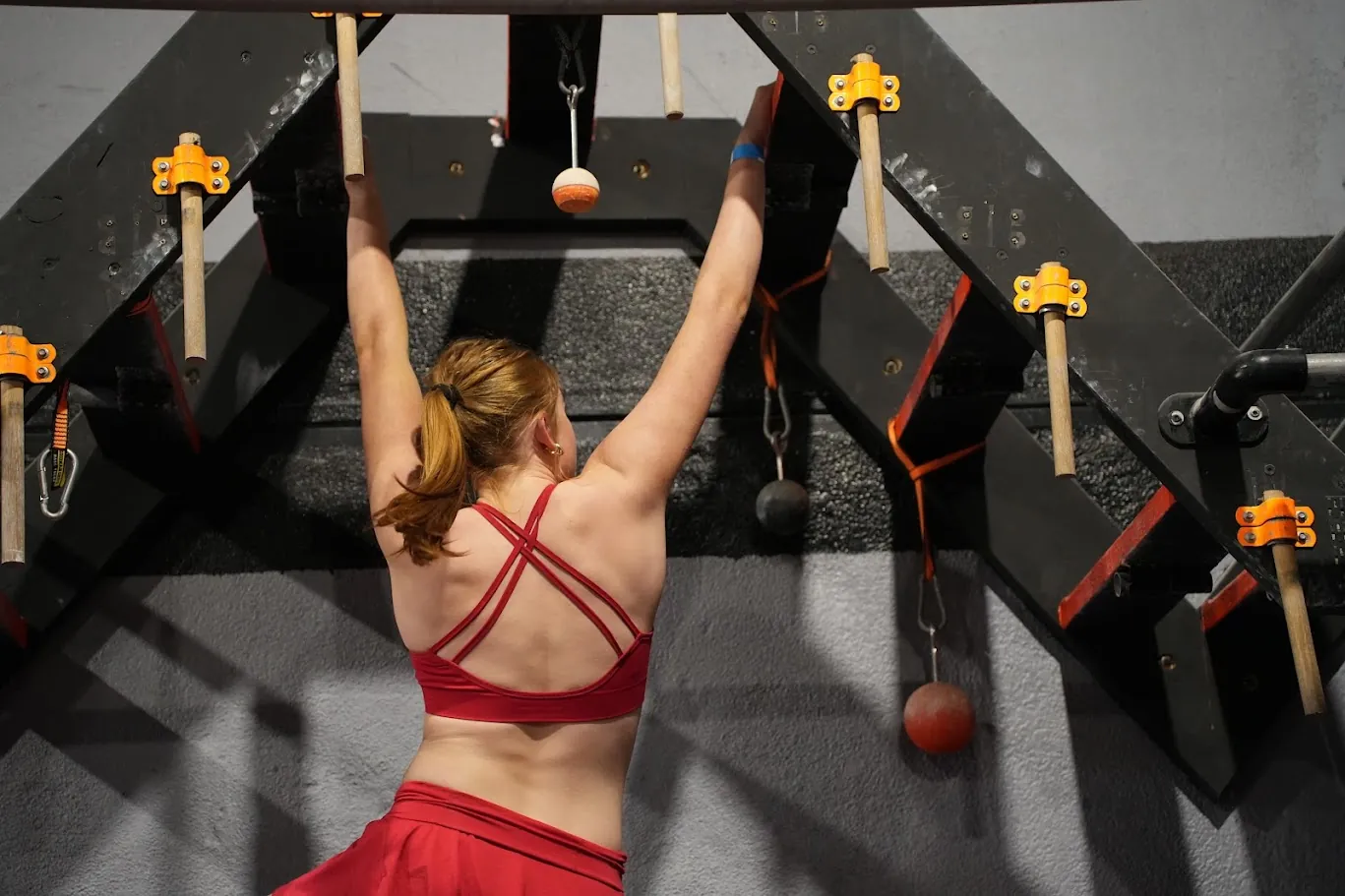 Competitor in red climbing the peg wall at AWF Gosford