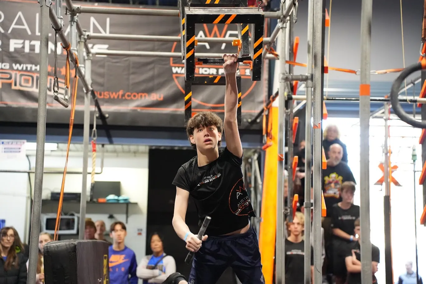 Young competitor holding a grip as the crowd watches at AWF