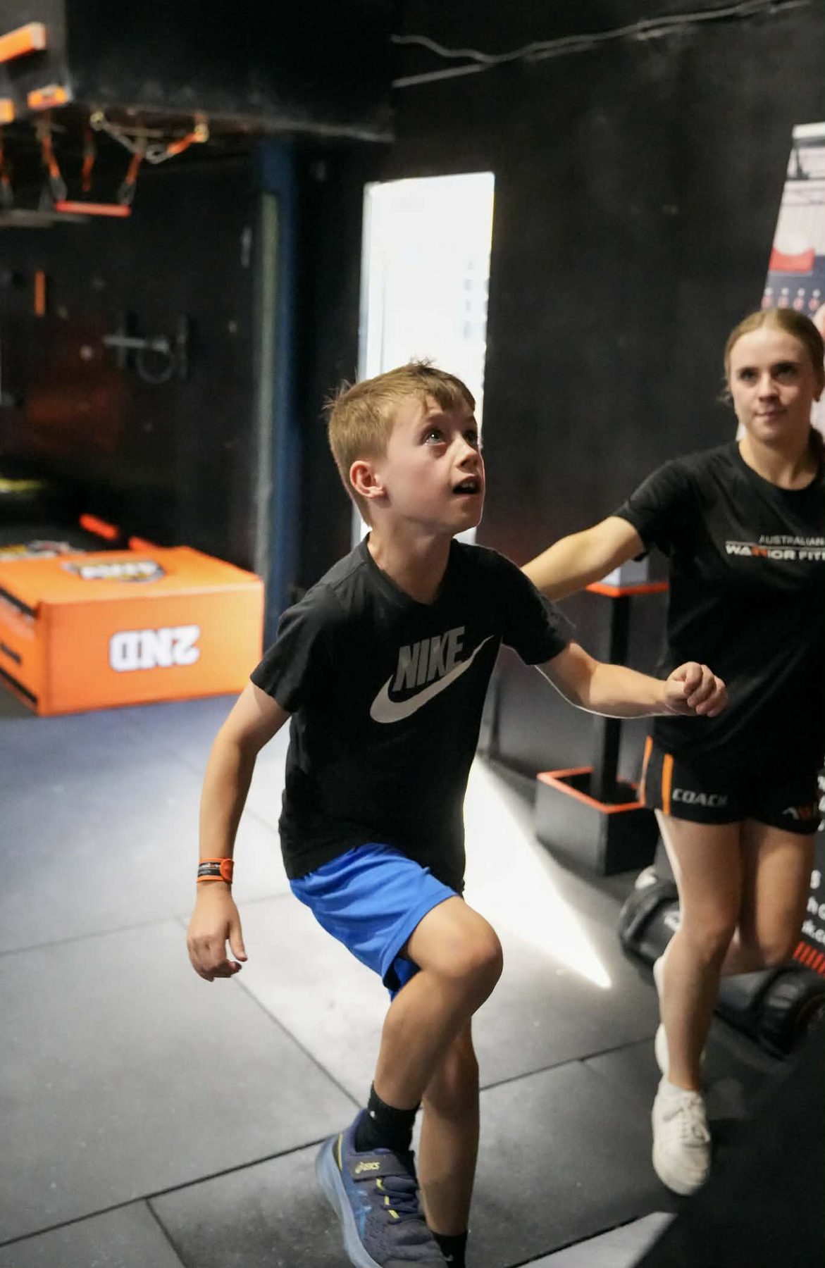 AWF coach cheering on a child at a kids ninja birthday party
